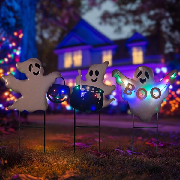 three ghost garden stakes with solar LED lights in the garden