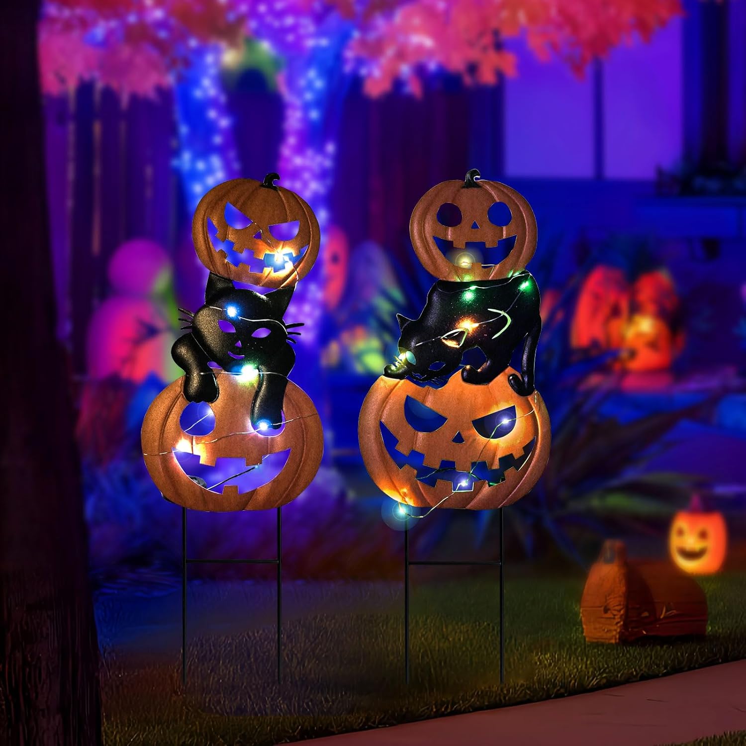 night view of a pair of pumpkin and black cat garden stake